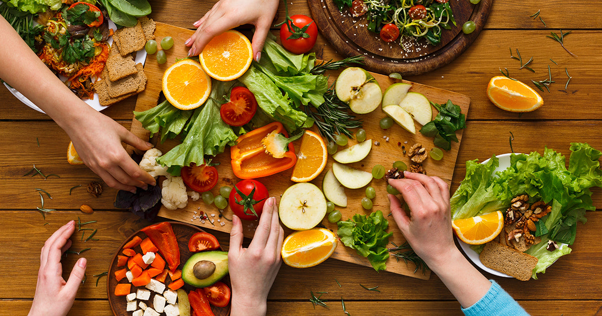 hands reaching for food on table